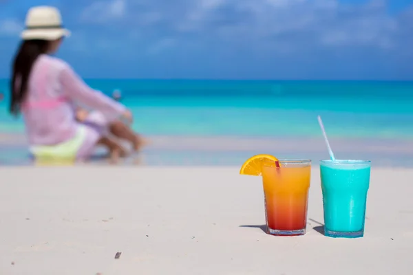 Närbild välsmakande drinkar på stranden bakgrund ung kvinna — Stockfoto