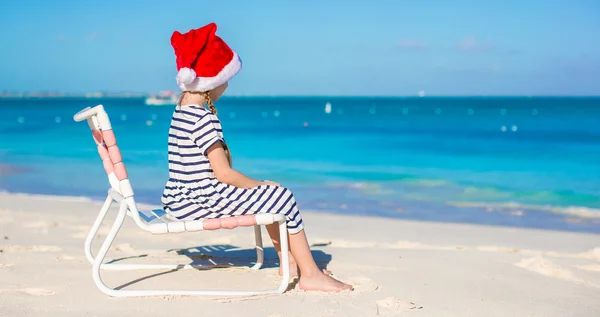 Little adorable girl in Santa hat at tropical white beach — Stock Photo, Image