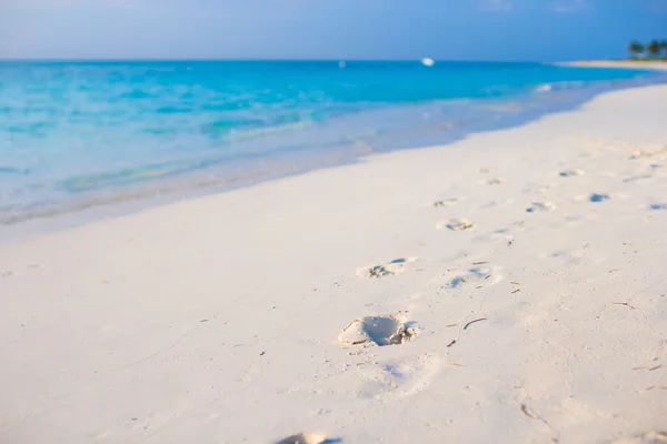 Beyaz kum plajı üzerinde insan ayak izleri — Stok fotoğraf