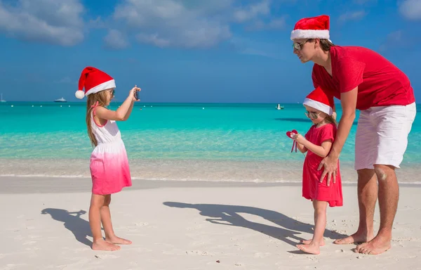 Little girl making photo on phone of her family at the beach — Stock Photo, Image