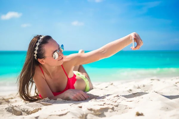 Schöne junge Frau fotografiert sich selbst am tropischen Strand — Stockfoto