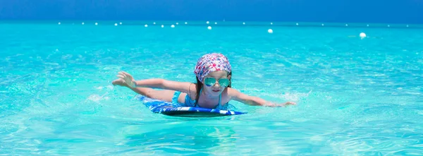 Rozkošná holčička v moři na tropické pláži dovolenou — Stock fotografie