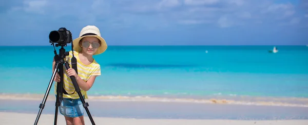 Little girl shooting with camera on tripod during her summer vacation — Stock Photo, Image