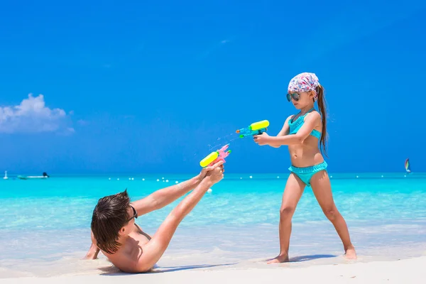 Szczęśliwy ojciec i jego urocza córeczka na tropikalnej plaży dobrze się bawią — Zdjęcie stockowe