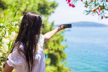 Arkadan Görünüm turist kadının güzel koy telefonu ile fotoğraf çekme