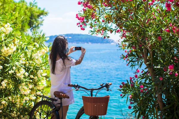 Vista posterior de la mujer turista tomando fotos con el teléfono en la hermosa bahía —  Fotos de Stock