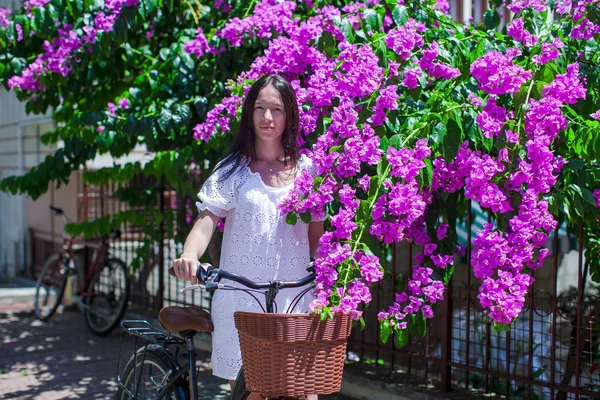 年轻漂亮的女人，在暑假骑自行车在美丽的街道上 — 图库照片