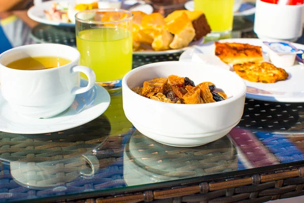 Leckeres Frühstück mit Flocken, Trockenfrüchten und Tee — Stockfoto