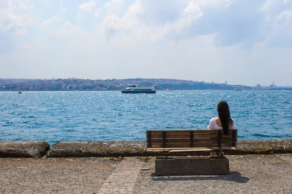 Junge attraktive Frau in den Sommerferien auf der Bank — Stockfoto