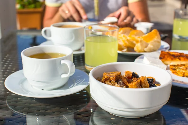 Delicioso desayuno con copos, fruta seca y taza de té —  Fotos de Stock