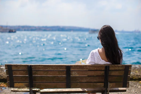 年轻漂亮的女性，在暑假期间坐在板凳上 — 图库照片