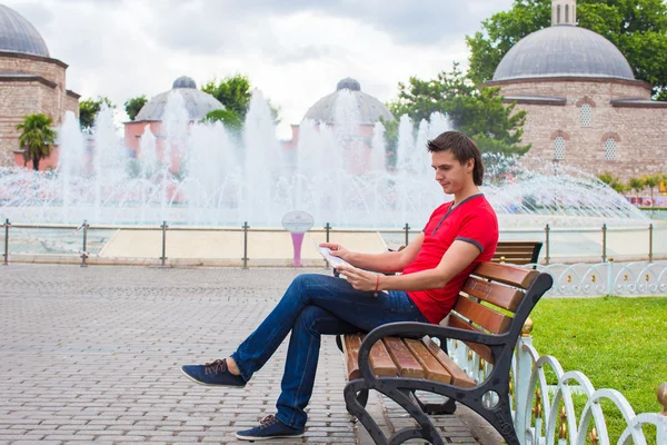 Retrato de un joven caucásico viajero leyendo un mapa — Foto de Stock