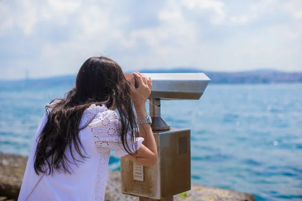 Mooi meisje kijken munt geëxploiteerd verrekijker op de Bosporus straat — Stockfoto