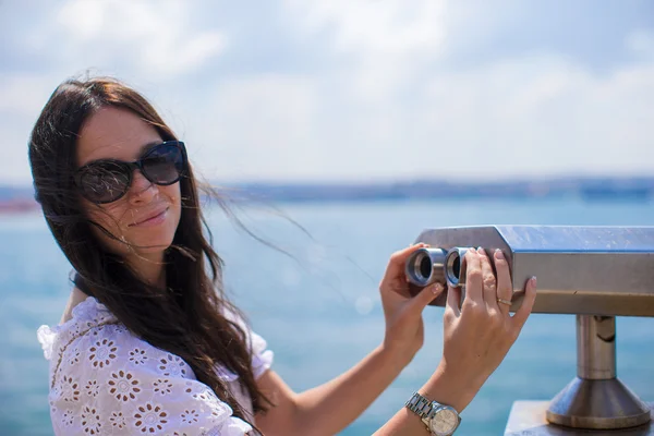 Hermosa chica mirando moneda operado binocular en el Estrecho del Bósforo —  Fotos de Stock