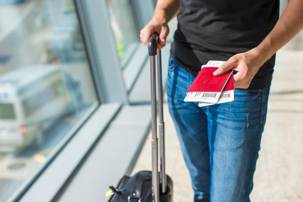 Homem segurando passaportes e cartão de embarque no aeroporto enquanto espera o voo — Fotografia de Stock