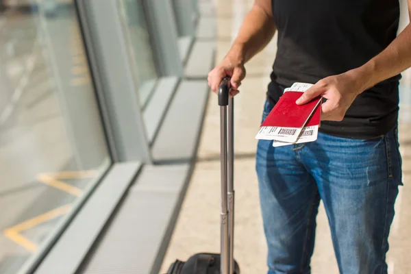 Homem segurando passaportes e cartão de embarque no aeroporto enquanto espera o voo — Fotografia de Stock