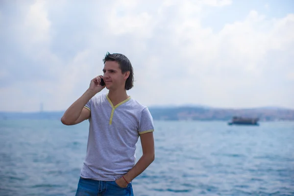 Young man talking by phone on background of the Bosphorus Strait — Stock Photo, Image