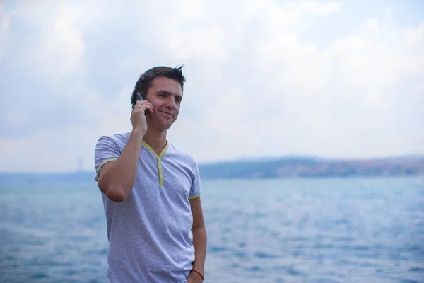 Young man talking by phone on background of the Bosphorus Strait — Stock Photo, Image