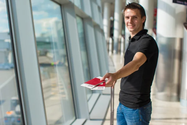 Man holding passports and boarding pass at airport waiting the flight — Stock Photo, Image