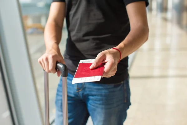 Homem segurando passaportes e passaporte de embarque no aeroporto esperando o voo — Fotografia de Stock