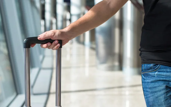Nahaufnahme eines Mannes mit Gepäck im Flughafen, während er auf den Flug wartet — Stockfoto