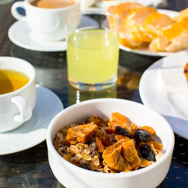 Heerlijk ontbijt met vlokken, gedroogde vruchten en kopje thee — Stockfoto