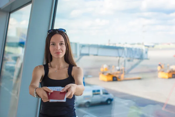 Kadın holding pasaport ve biniş kartı havaalanında uçuş bekliyor — Stok fotoğraf