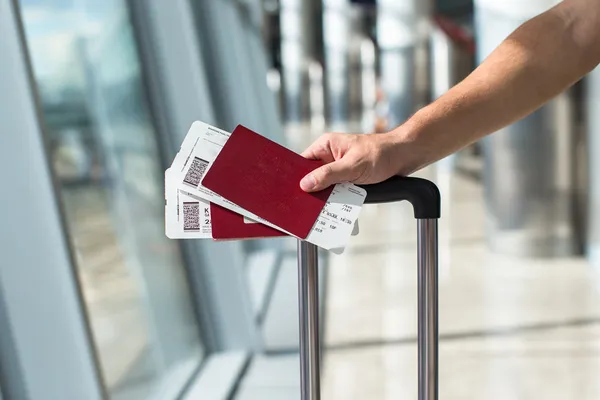 Gros plan de l'homme titulaire d'un passeport et d'une carte d'embarquement à l'aéroport — Photo