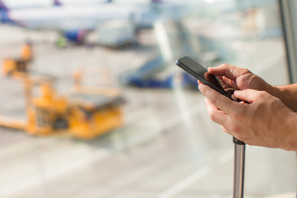 Закрыть руки людей с помощью мобильного телефона в аэропорту
