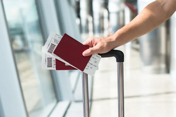 Close up de mãos masculinas segurando passaportes e cartão de embarque no aeroporto — Fotografia de Stock