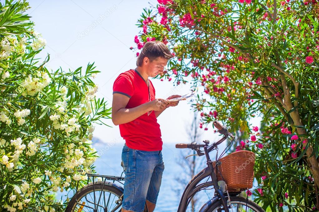 Young caucasian traveling man reading a map