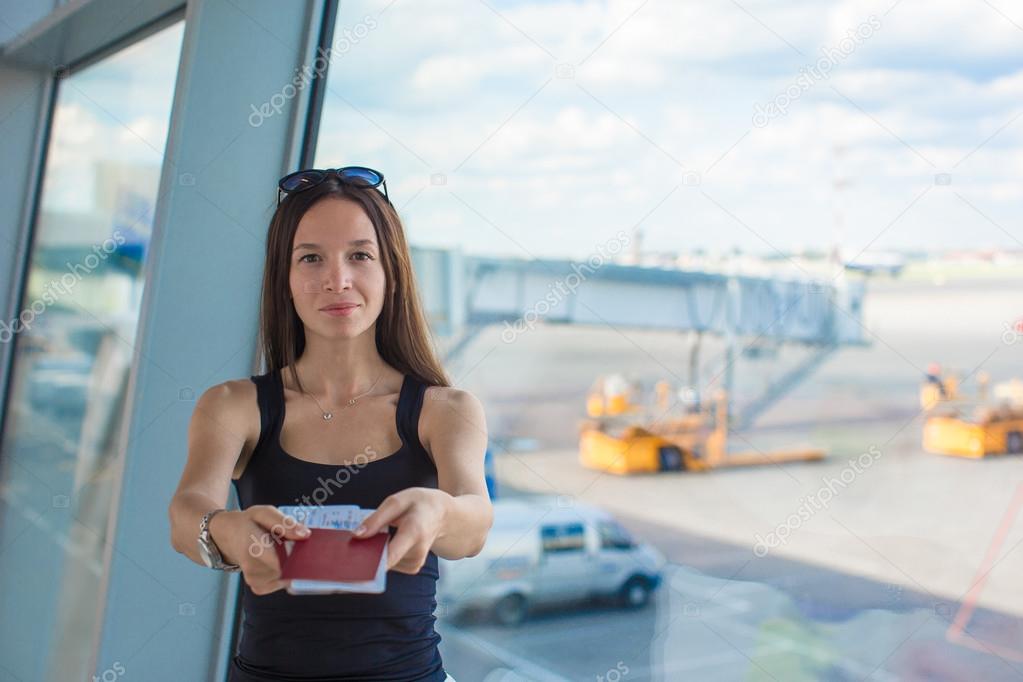 Woman holding passports and boarding pass at airport waiting the flight