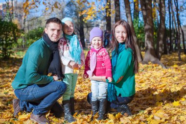 Sevimli küçük kız güneşli sonbahar Park ile genç aile