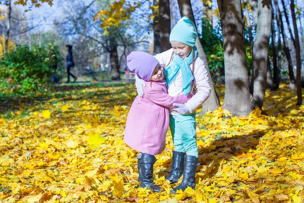 Two adorable little girls having fun at autumn park — Stock Photo, Image