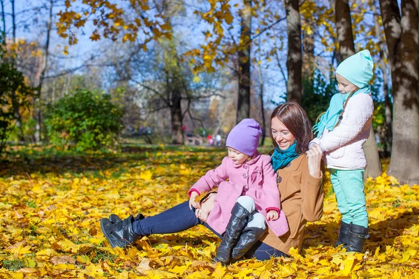 Little girls and young mother in autumn park — Stock Photo, Image