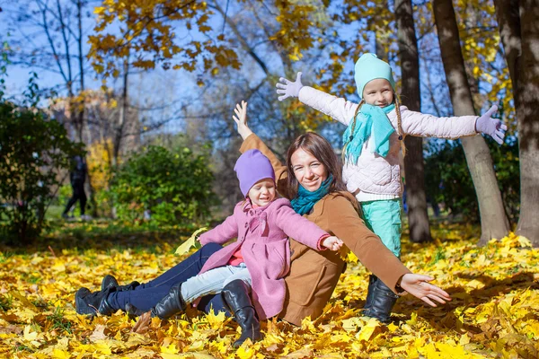 Little cute girls and young mother in autumn park have fun — Stock Photo, Image