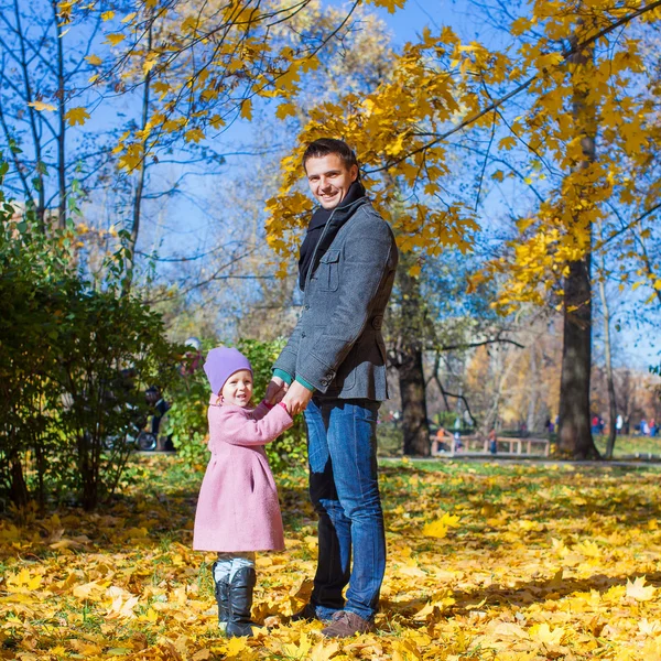 Bedårande liten flicka med glada far utomhus i höst park — Stockfoto