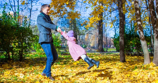 Sevimli küçük kız ve mutlu baba sonbahar parkta eğleniyor — Stok fotoğraf