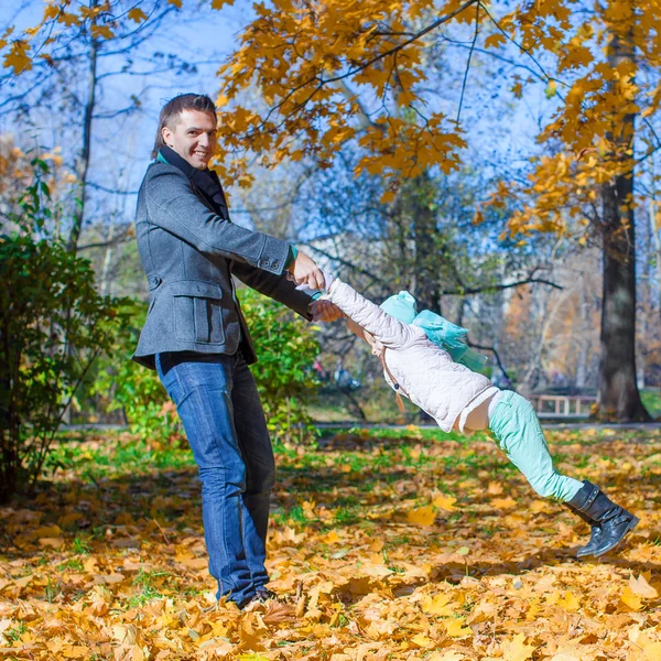 Schattig meisje met gelukkig papa plezier in herfst park op een zonnige dag — Stockfoto