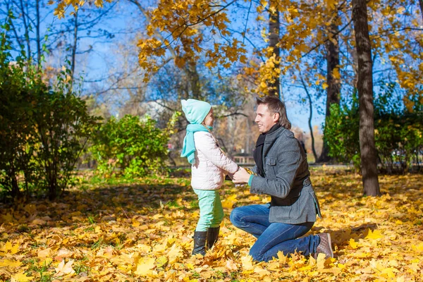 Счастливый отец с милой дочкой в осеннем парке под открытым небом — стоковое фото