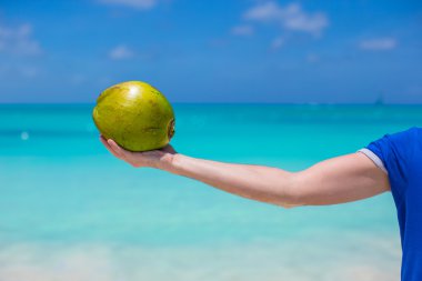 elinde Hindistan cevizi closeup arka plan, turkuaz deniz