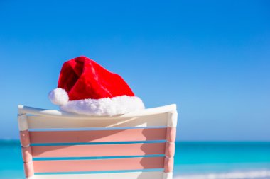 tropikal plaj sandalye longue üzerinde santa şapka yukarıya kapatmak
