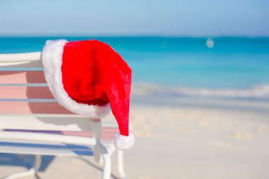 tropikal plaj sandalye longue üzerinde santa şapka yukarıya kapatmak