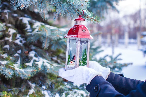 Beautiful red decorative Christmas lantern on warm mittens — Stock Photo, Image