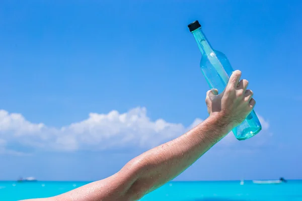 Flaska med budskap på handen — Stockfoto