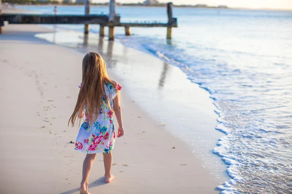 Sevimli küçük kız beyaz tropik sahilde sunset bulvarında yürürken — Stok fotoğraf