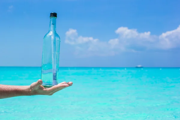 瓶用手背景蓝色天空中的消息 — 图库照片