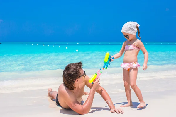 Отец и девочка на тропическом пляже веселятся — стоковое фото