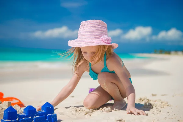 小さな女の子が熱帯の休暇中にビーチおもちゃで遊んで — ストック写真