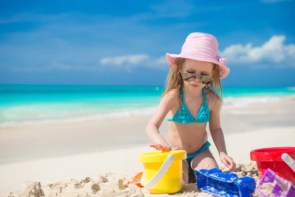 Little cute girl gra z zabawek na plaży podczas tropikalnych wakacji — Zdjęcie stockowe